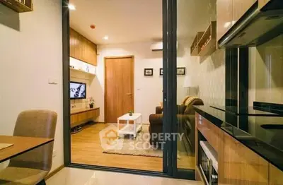 Modern open-plan living room and kitchen with stylish decor and wooden accents.