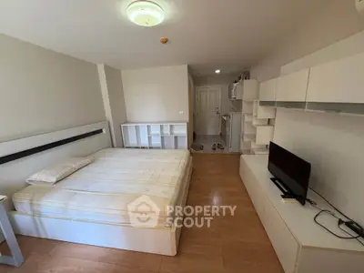 Spacious bedroom with modern furnishings and wooden flooring in a stylish apartment.