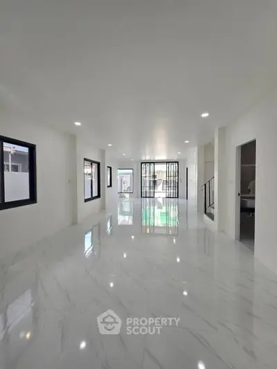 Spacious modern living room with glossy marble floors and large windows