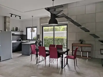 Modern open-plan kitchen and dining area with sleek design and large windows.