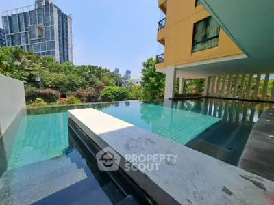 Luxurious apartment pool with stunning cityscape view and lush greenery