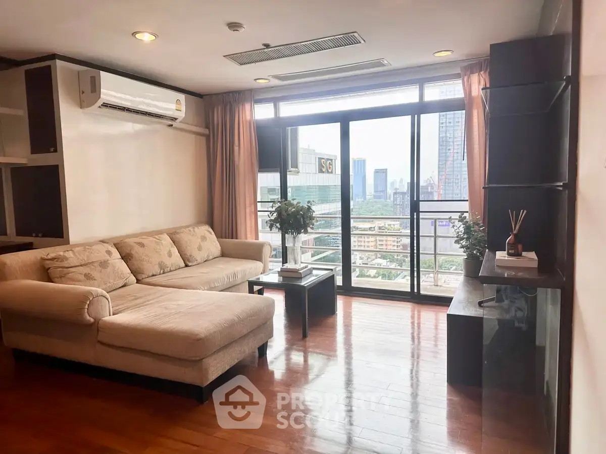 Spacious living room with city view and modern furnishings in high-rise apartment.