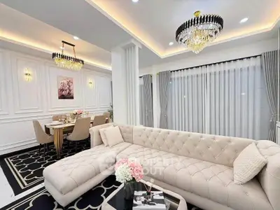 Luxurious living room with elegant chandelier and plush sectional sofa in modern home.