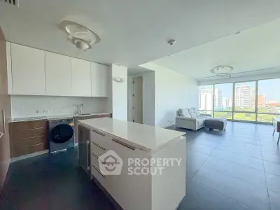 Spacious modern living room with open kitchen and city view
