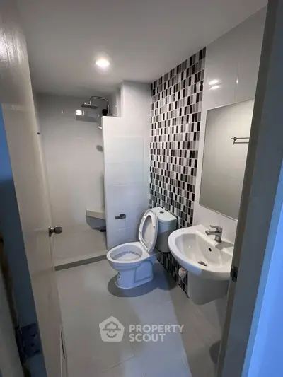 Modern bathroom with sleek fixtures and stylish tile design, perfect for contemporary living.