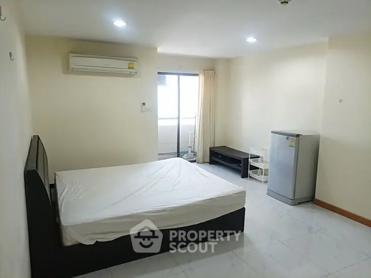 Spacious bedroom with air conditioning and balcony access