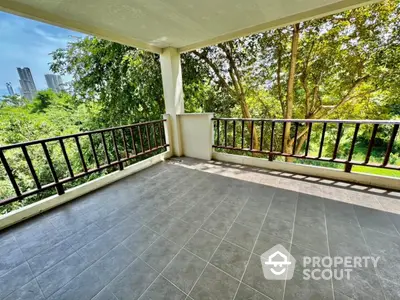 Spacious balcony with lush greenery and city skyline view