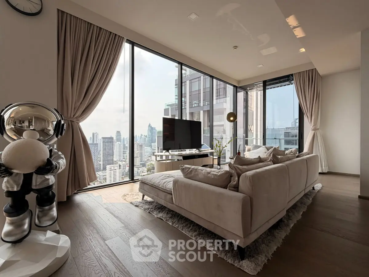 Luxurious living room with floor-to-ceiling windows offering stunning city views, modern decor, and plush seating.