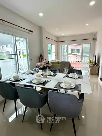 Elegant dining area with modern decor and large windows in a stylish home.