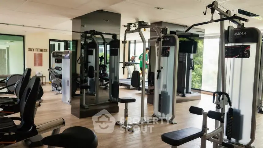 Modern gym with state-of-the-art fitness equipment and mirrored walls in a luxury apartment complex.