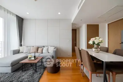 Modern living room with cozy sectional sofa and elegant dining area, featuring wooden flooring and stylish decor.
