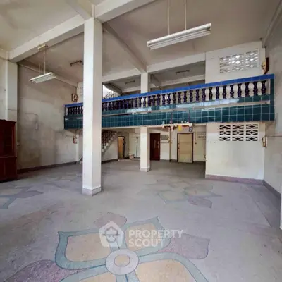 Spacious interior with unique tiled flooring and mezzanine level, ideal for creative use.