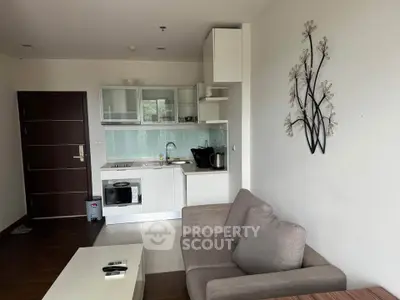 Modern open-layout living room with compact kitchen and stylish decor