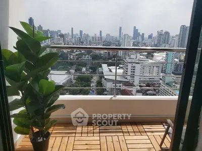 Stunning cityscape view from a modern balcony with wooden flooring and lush plant.
