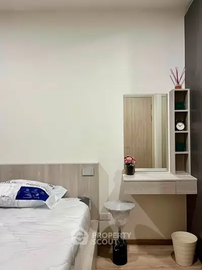 Modern bedroom with stylish decor and functional furniture, featuring a cozy bed and elegant vanity area.