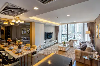 Luxurious open-plan living room with dining area and city view, featuring elegant decor and modern furnishings.
