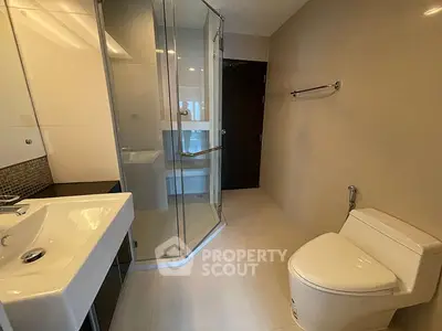 Modern bathroom with glass shower and sleek fixtures in a contemporary home.