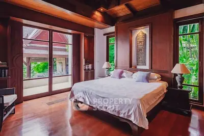 Luxurious bedroom with wooden accents and garden view in tropical villa