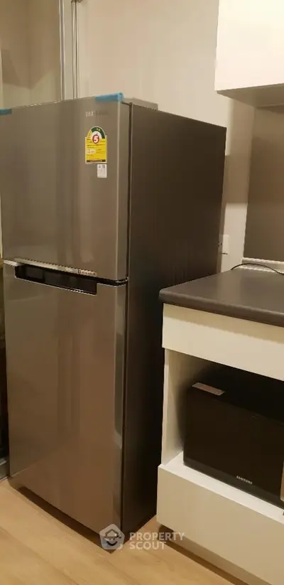 Modern kitchen with sleek stainless steel refrigerator and contemporary cabinetry.