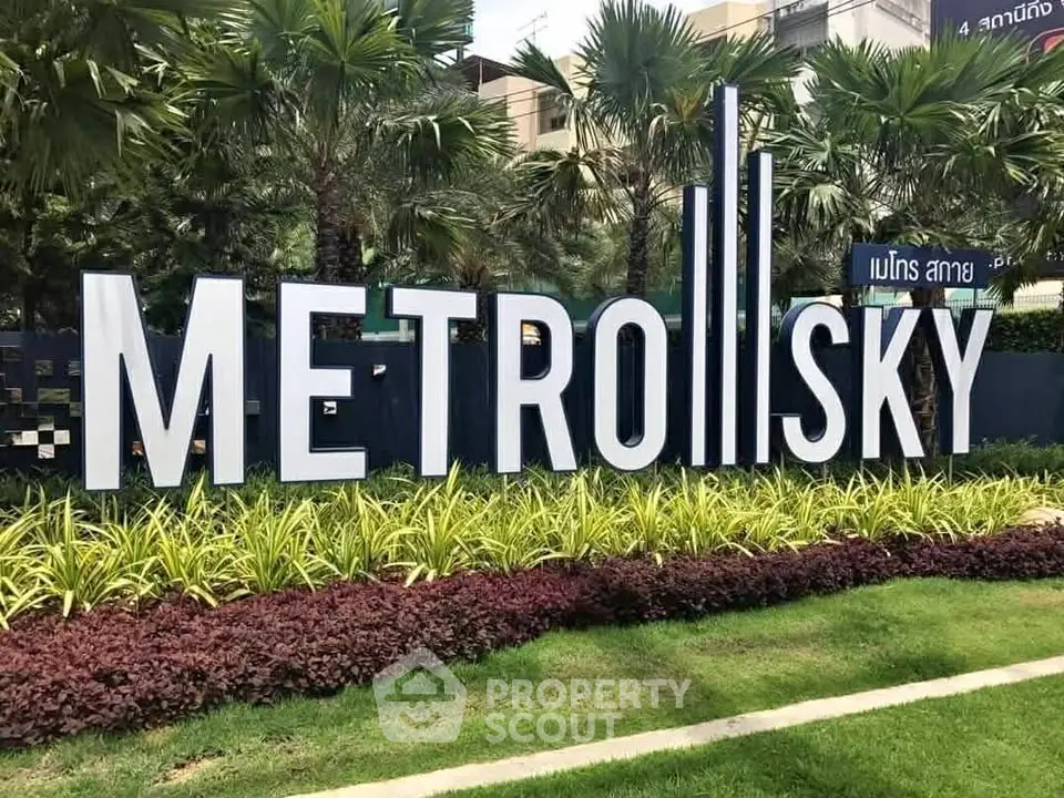 Modern Metro Sky building entrance with lush landscaping and contemporary signage.