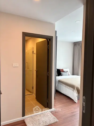 Modern bedroom with ensuite bathroom featuring sleek design and cozy ambiance.