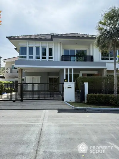 Elegant modern two-story house with large windows and landscaped front yard in a serene neighborhood.