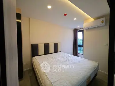 Modern bedroom with large window and air conditioning in a stylish apartment.