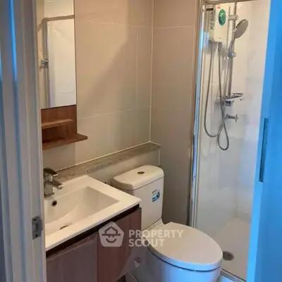 Modern bathroom with sleek fixtures and glass shower enclosure in a contemporary apartment.