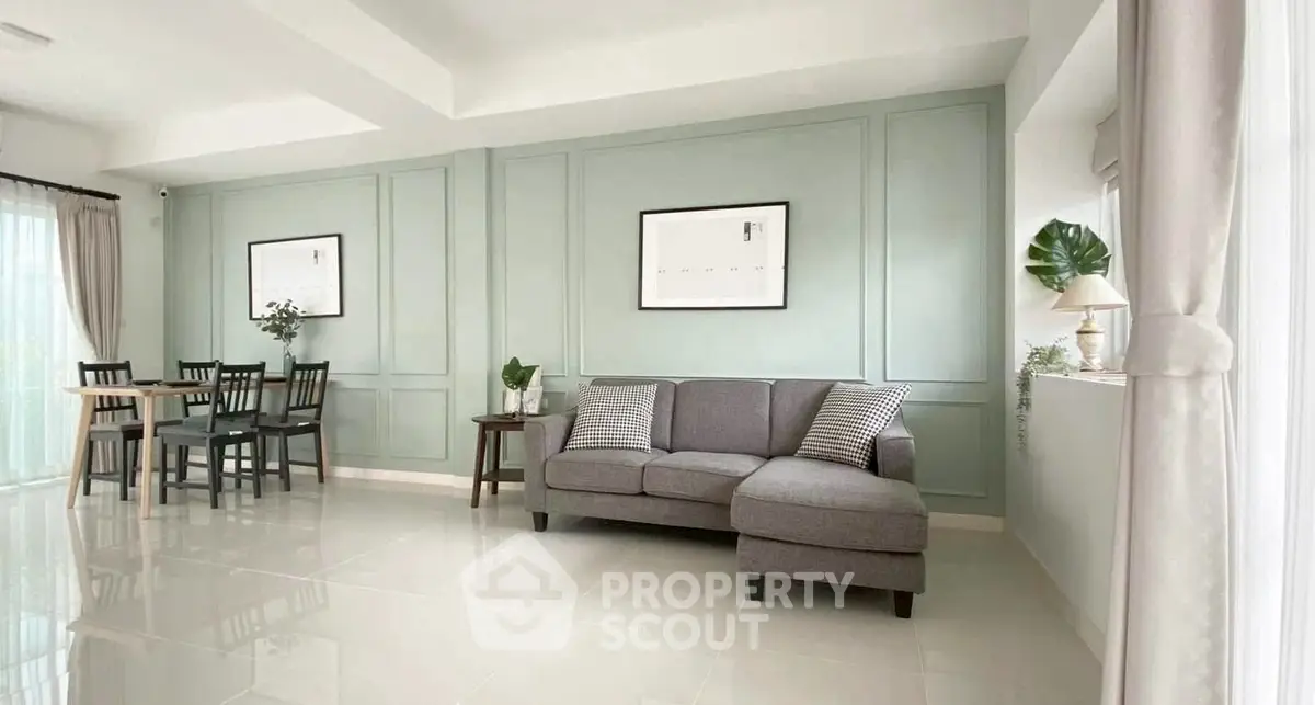 Elegant living room with modern decor and dining area, featuring stylish furniture and natural light.