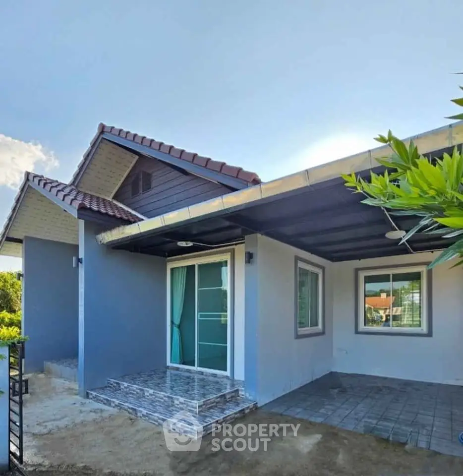 Charming single-story home with modern exterior and tiled entrance in a serene neighborhood.