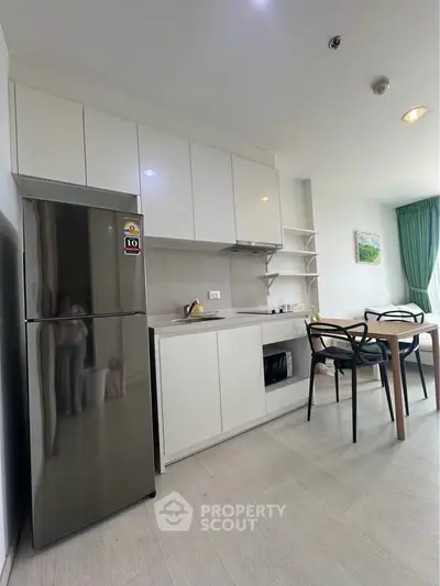 Modern kitchen with sleek white cabinets and dining area in a bright apartment