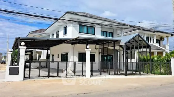 Modern two-story house with sleek design and spacious driveway in a suburban neighborhood.