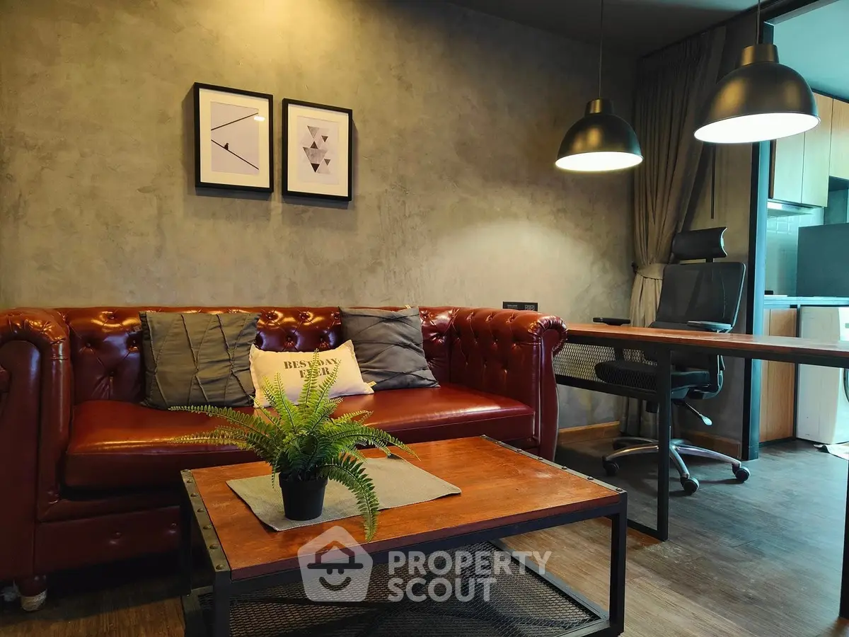 Stylish living room with leather sofa, modern lighting, and cozy workspace in open layout apartment.