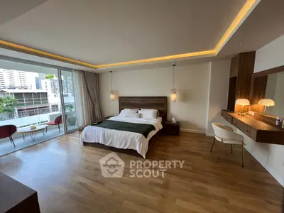 Spacious modern bedroom with elegant wooden flooring and large balcony access in luxury apartment.