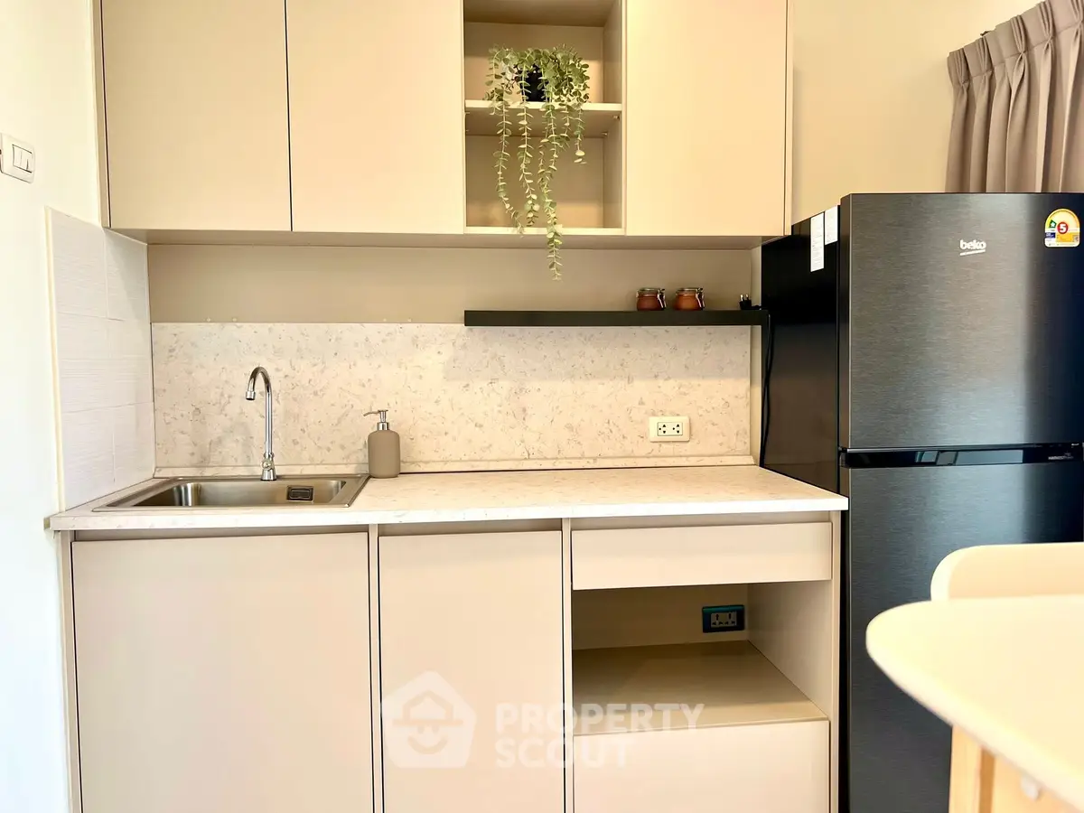 Modern kitchen with sleek cabinetry and stainless steel fridge