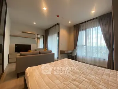 Modern bedroom with cozy living area and large windows offering natural light.