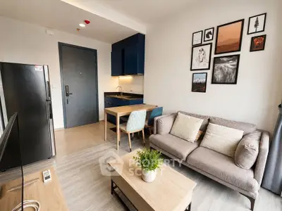 Modern living room with cozy sofa, stylish decor, and compact kitchen in open layout apartment.