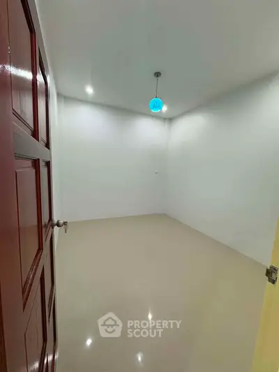 Spacious empty room with glossy floor and modern lighting, perfect for customization.