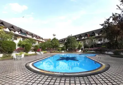 Charming residential complex with inviting outdoor pool and lush greenery.