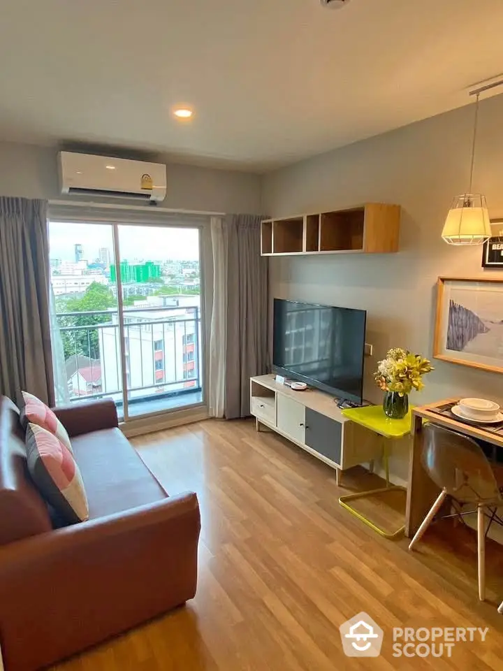 Modern living room with balcony view, stylish furniture, and natural light in urban apartment.