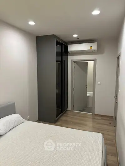 Modern bedroom with air conditioning and ensuite bathroom in a stylish apartment.