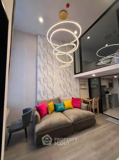 Modern living room with stylish lighting and colorful cushions in a contemporary apartment.
