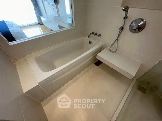 Modern bathroom with sleek bathtub and shower in contemporary apartment.