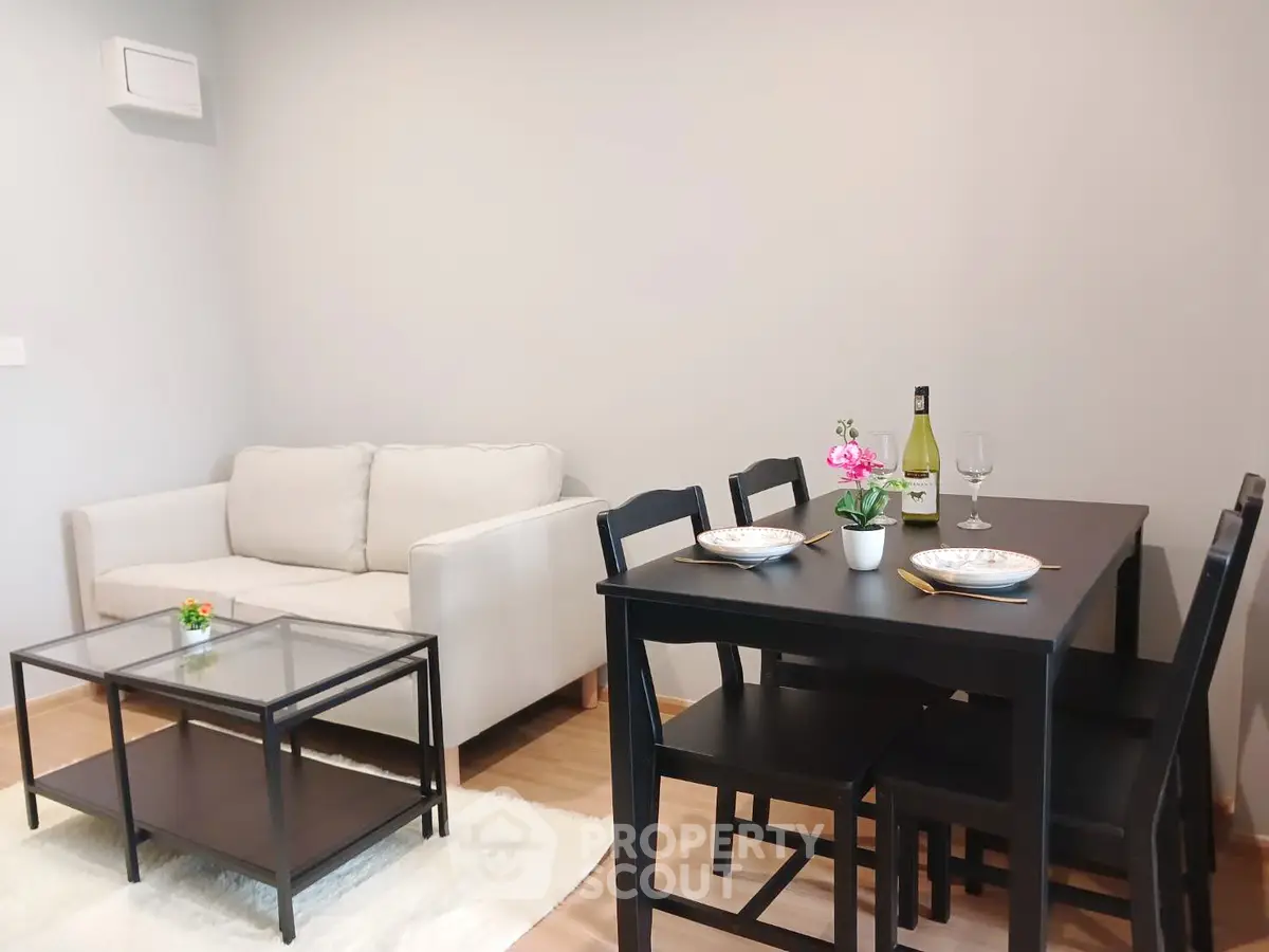 Cozy living room with modern dining set and comfortable sofa, perfect for small gatherings.