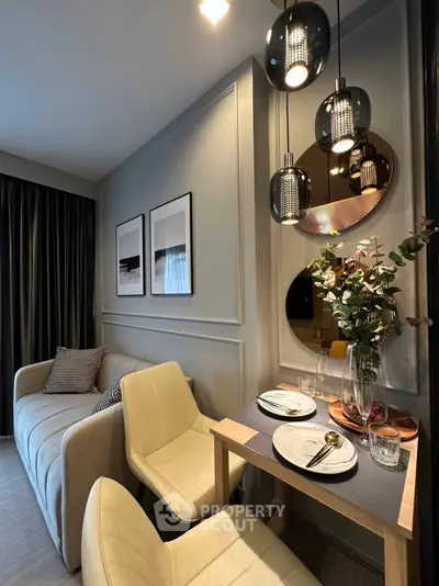 Stylish modern living room with elegant dining area and chic lighting fixtures.