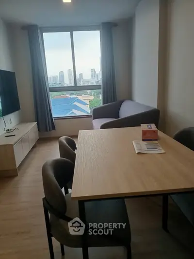 Modern living room with city view, stylish furniture, and natural light.