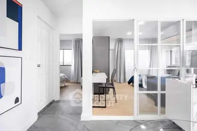 Modern apartment interior with glass partition, stylish decor, and natural light.