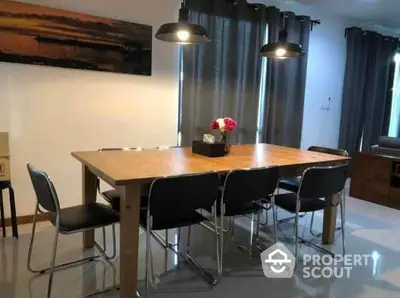 Modern dining area with wooden table and stylish chairs in a cozy home setting.