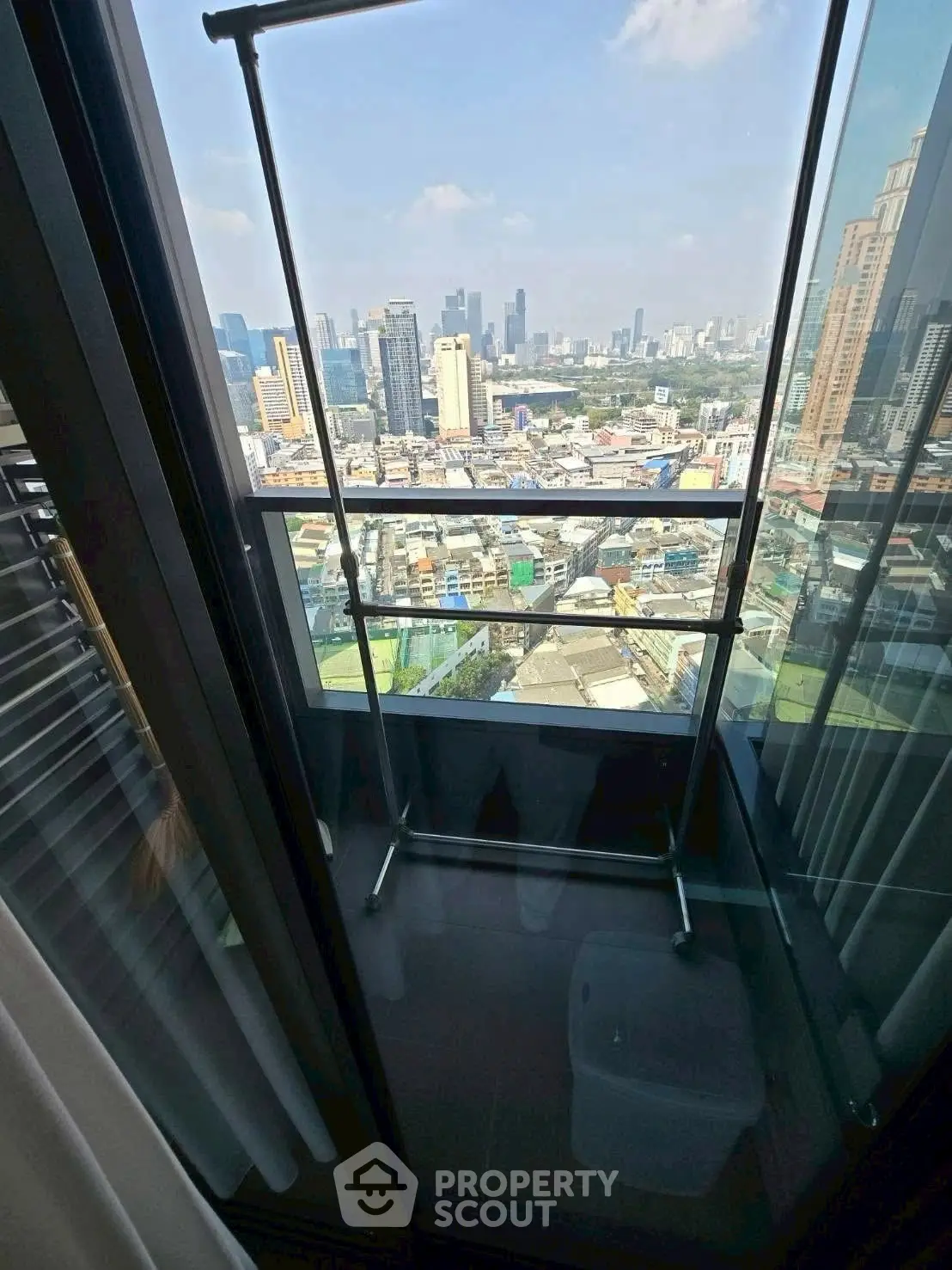 Stunning city view from a high-rise balcony with modern glass railing.