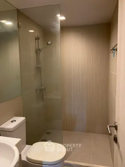 Modern bathroom with glass shower and sleek fixtures in a contemporary apartment.
